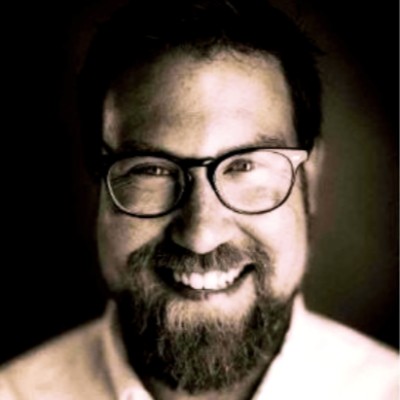 Max Dichter, smiling and wearing glasses